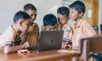 Schoolkids looking at computer. Agung Pandit